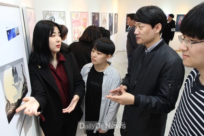 유서미(2학년) 씨가 자신의 ‘DIY LED 무드 램프 디자인-밤하늘을 여행하는 고래선’ 작품을 김준영 지도교수와 학우들에게 설명하고 있다.