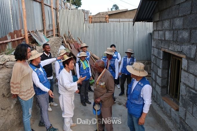한국도로공사 해외봉사단원들이 참전용사마을의 개보수된 주택을 둘러보고 인사를 나누고 있다.