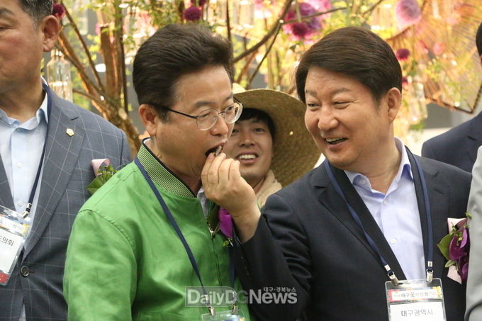 '제10회 대구꽃박람회' 기념 떡 절단식 후 권영진 대구시장이 이철우 경상북도지사에게 떡을 먹여 주고 있다. (사진=이준호 기자)