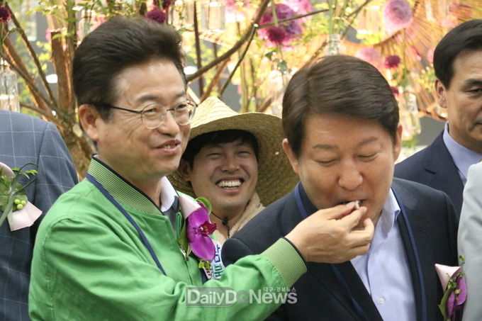 '제10회 대구꽃박람회' 기념 떡 절단식 후 이철우 경상북도지사가 권영진 대구시장에게 떡을 먹여 주고 있다. (사진=이준호 기자)