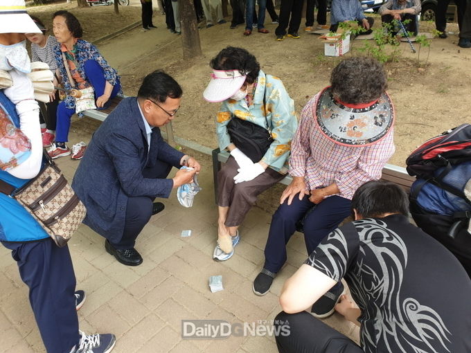 대구 서구청은 9일 찾아가는 교통안전교육을 실시하고, 어르신 신발에 '반딧불 스티커'를 붙여 드리고 있다. (사진=서구청 제공)