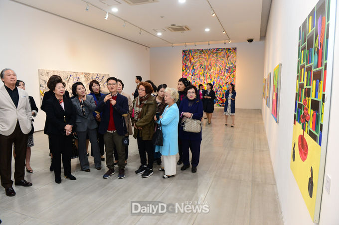 24일 열린 전시회 오픈식에서 남성희 총장을 비롯한 내외빈이 홍경택 작가로부터 작품설명을 듣고 있다. (사진=대구보건대 제공)