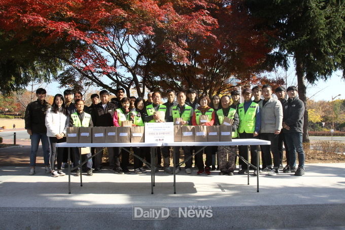 계명대학교 학생회 학셍들이 교내 청소용역 선생님들께 방한용품을 전달하고 기념촬영을 하고 있다. (사진=계명대 제공)