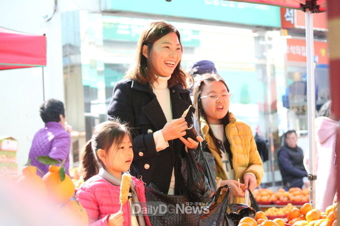 현풍장날 둘째, 넷째 딸과 함께 웃고 있는 전유진 예비후보. (사진=전유진 예비후보 제공)