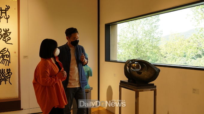 솔거미술관에서 열리고 있는 '경주 원로작가 초대전'을 방문한 관람객이 박원섭 작가의 작품 '여명'을 관람하고 있다.