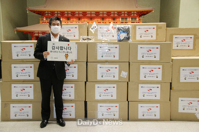 경주시에서 보낸 방역물품 앞에서 ‘감사합니다’ 팻말을 들고 있는 나카가와 겐(仲川げん) 나라시장.