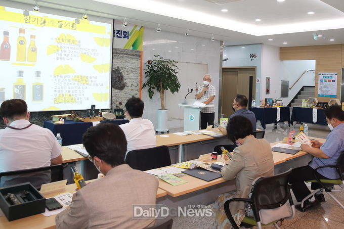 칠곡 각산마을협동조합(말하는 은행나무) 장세완 이사장이 참기름과 생들기름을 바이어에게 설명하고 있다.