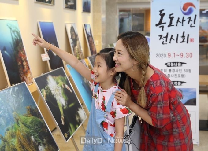 사진제공 칠곡군) 이지연(40·女·석적읍)씨가 9월 7일 자녀 조예린(대교초·4)양과 대한민국특수임무수행자회 경북지부 주체로 열린 ‘독도 사진전’을 찾아 작품을 감상하고 있다.