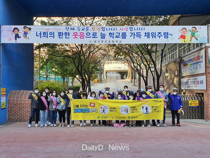 대구 달성군과 죽곡초등학교 교직원, 학생들이 20일 초등학교 주변 어린이보호구역구역에서 불법 주정차 금지 캠페인을 실시하고 기념촬영을 하고 있다. (사진=달성군 제공)
