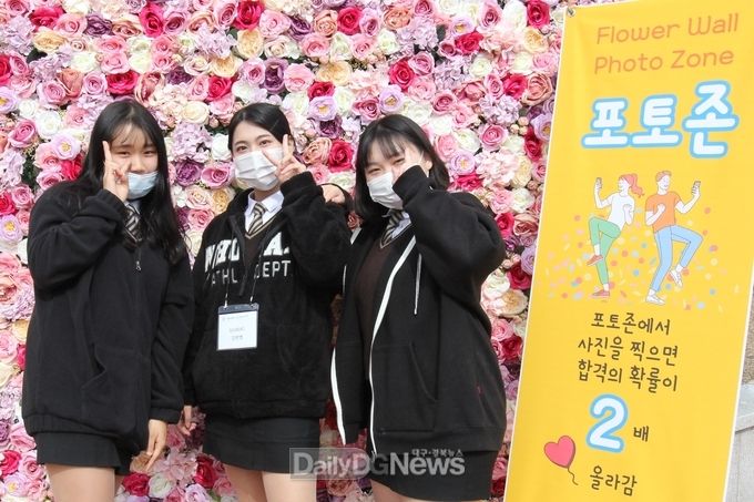 장미송이로 가득한 포토존에서 3명의 면접생이 추억의 사진을 찍고 있다.