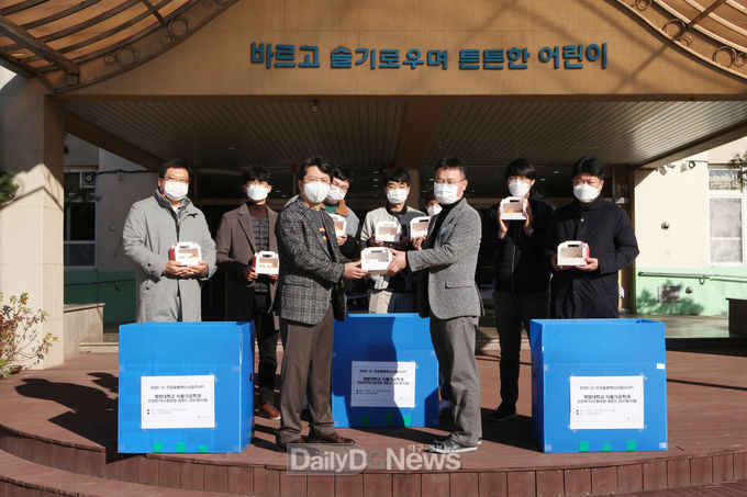 계명대 식품가공학전공 교수와 학생들이 25일 신당초등학교에 기능성 청국장 빵을 전달하고 있다. (사진=계명대 제공)