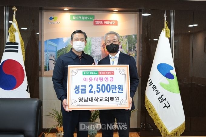 김성호 영남대병원장(오른쪽)이 29일 조재구 남구청장(왼쪽)에서 이웃사랑성금 2,500만 원을 전달하고 있다. (사진=영남대병원 제공)