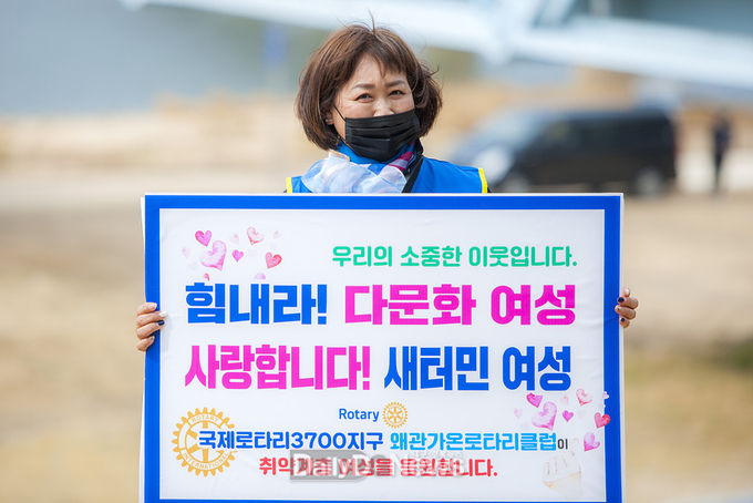 칠곡군 왜관가온라타리클럽이 3월 21일 칠곡보생태공원 일원에서 회원 20여 명이 참여한 가운데 취약계층 여성을 응원하는 캠페인과 환경정화활동을 펼쳤다. 사진은 박은화 왜관가온로타리 클럽회장이 플랜카드를 들고 있는 모습