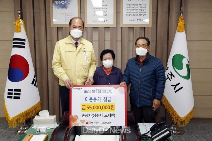 상주시 제공) 상주시 모서면 호음리의 손광자(사진 가운데)씨가 4월 5일 상주시청을 방문하여 생활이 어려운 사람들에게 써달라며 5,500만원을 쾌척하고 기념촬영을 하고 있다.