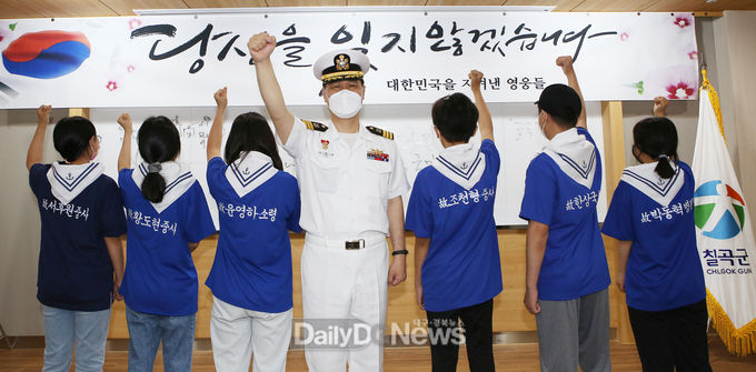 이희완 중령이 가운데 서고 학생들이 얼굴대신 등에 새겨진 희생 장병 6명의 이름을 보이는 내가 참전용사다 퍼포먼스를 펼치고 있다.