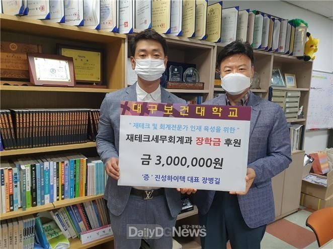 장병길 진성하이텍 대표(왼쪽)가 성백춘 교수(오른쪽)에게 장학금을 전달하고 기념촬영을 하고 있다. (사진=대구보건대 제공)