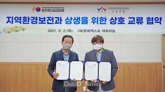 2일 업무협약식에서 류희림 경주엑스포대공원 사무총장(왼쪽)과 정기룡 한국원자력환경공단 노동조합 위원장(오른쪽)이 협약서에 서명 후 기념촬영을 하고 있다