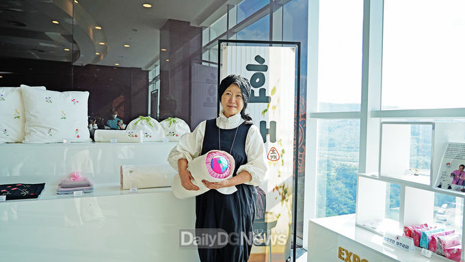 23일 업무협약 체결 후 경주타워 기념품 샵에서 판매중인 자신의 작품 앞에서 기념 촬영을 하고 있는 이효재 문화디자이너