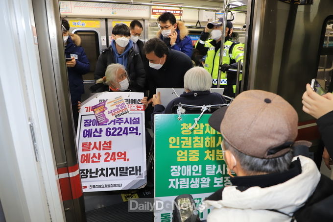 대구장애인단체 소속 장애인들과 활동가들이 14일 대구지하철 1호선 반월당 역에서 청암재단 폐쇄를 요구하며 열차 운행을 중단시키는 시위를 벌이고 있다. (사진=이준호 기자)