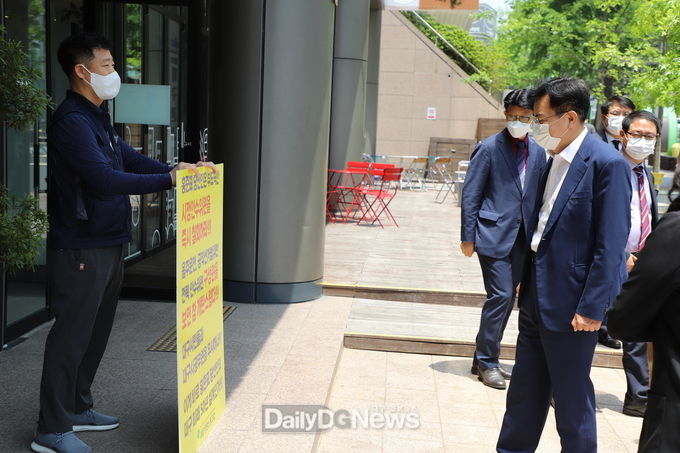 이상길 대구시장 인수위원회 위원장이 장재형 위원장의 1인 피켓 시위 문구를 바라보고 있다. (사진=이준호 기자)