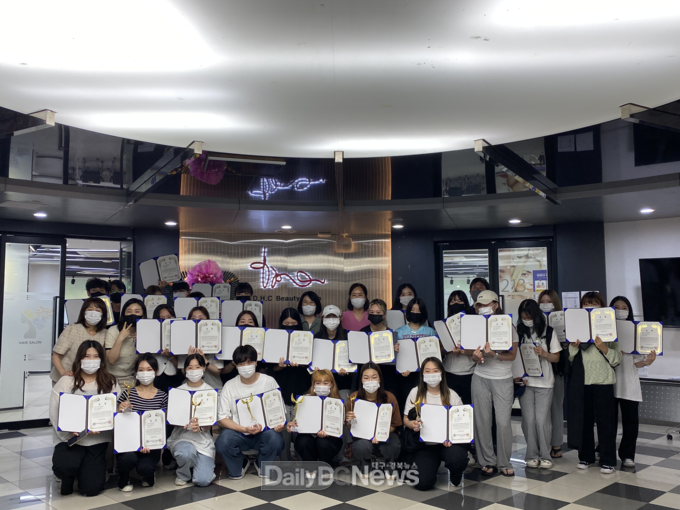 대구보건대학교 뷰티코디네이션과 교수와 학생들이 교내 학과실습실 앞에서 최근 열린 3개 뷰티대회에서 수상한 상장을 들고 기념 촬영을 하고 있다. (사진=대구보건대 제공)