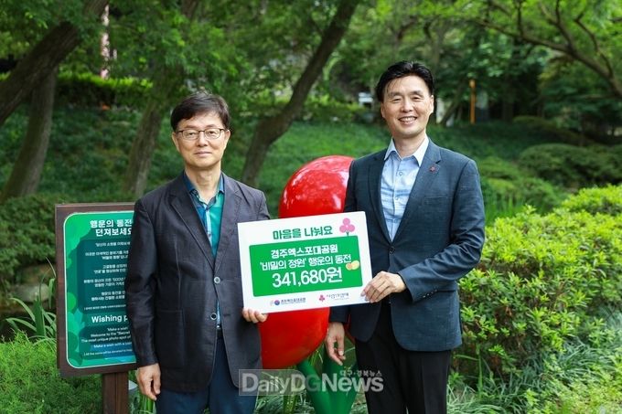 정규식 경주엑스포사무총장이 정동의 경북사회복지공동모금회 사무처장에게 ' 행운의 동전' 성금을 전달하고 있다