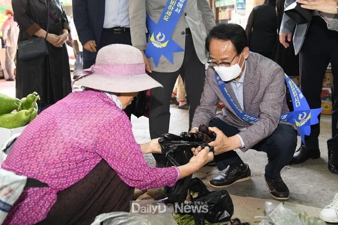 박남서 시장이 장보기 행사에서 가지를 구매하고 있다