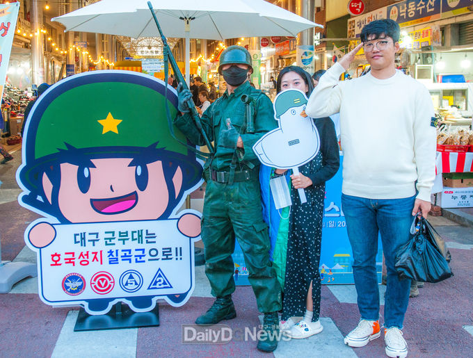 칠곡군 제공) 연극배우 이재선 씨는 왜관 1번도로에서 고 이인호 해병 소령을 소재로 한 ‘이등병의 편지’ 무언극 공연을 펼치는 것은 물론 홍보판을 배경으로 주민과 기념 촬영을 하며 칠곡군부대 유치를 응원하고 있다.