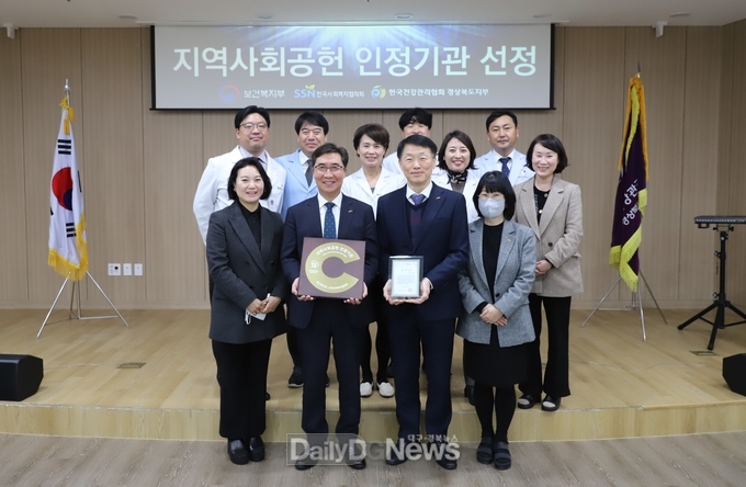 건협 경북지부 강위중 본부장(중앙 왼쪽)과 이강원 사업관리부장(중앙 오른쪽)이 지역사회공헌인정패와 포항시장 감사장을 각각 들고 직원들과 함께 기념사진을 촬영하고 있다.