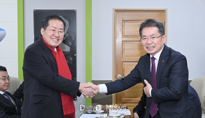 홍준표 대구시장(왼쪽)과 김진열 군위군수(오른쪽)가 16일 군위군청에서 악수를 하고 있다. (사진=대구시 제공)