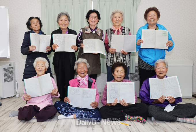 칠곡군 왜관8리 달오경로당 할머니들이 우크라이나를 응원하는 메시지를 작성하고 기념촬영을 하고 있다.