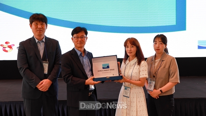 정규식 본부장과 김리나 마케팅팀장(사진가운데)이 코리아 유니크 베뉴 현판을 들고 관계자들과 기념사진을 찍고 있다