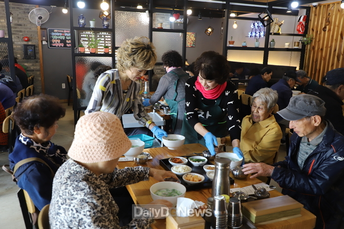 ‘소문난 부자돼지국밥’ 평리점 김희숙 대표와 '명품서구만들기' 회원들이 어르신들에게 돼지국밥을 무료로 제공하는 모습. (사진=이준호 기자)