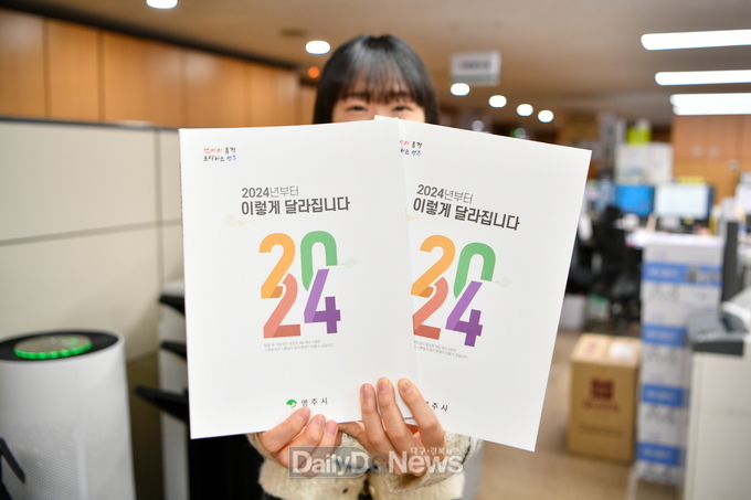  영주시 직원이 _2024년부터 이렇게 달라집니다_ 책자를 들고 있다