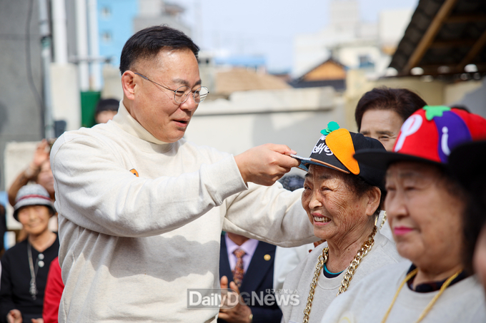 김재욱 칠곡군수가 칠곡할매래퍼 그룹 텃밭 왕언니 창단식에 참석해 할머니들에게 힙합 그룹을 상징하는 모자를 씌워주며 격려하고 있다.