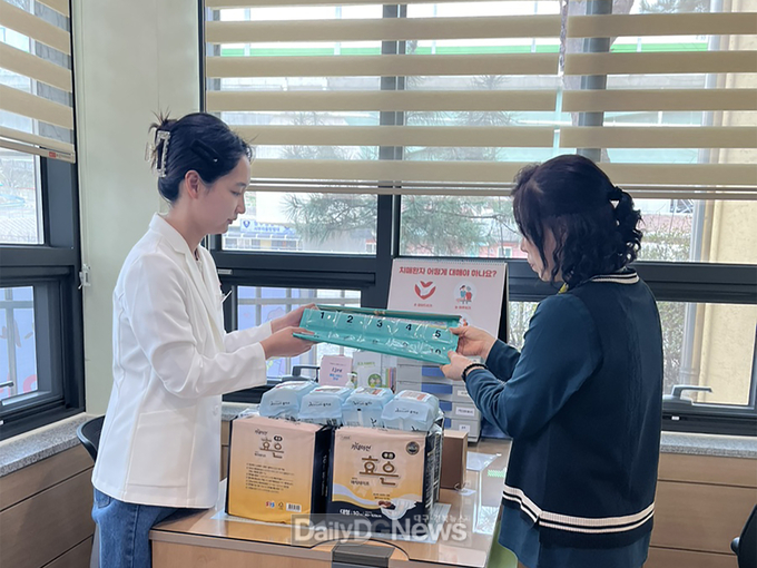  시 직원이 치매환자 조호물품을 환자 보호자에게 전달하고 있다