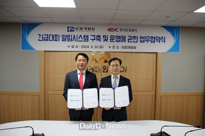 5.31. 보험개발원에서 열린 ‘긴급대피 알림시스템 구축’ 업무협약 체결식에 참석한 한국도로공사 설승환 교통본부장(왼쪽)과 보험개발원 박진호 부원장(오른쪽)이 기념촬영을 하고 있다.