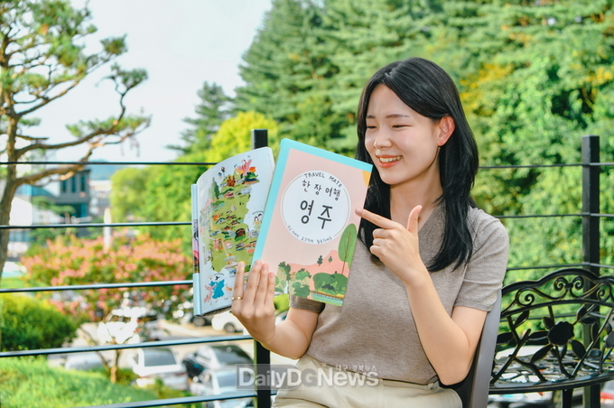 영주시 직원이 _한 장 여행_ 지도를 소개하고 있다