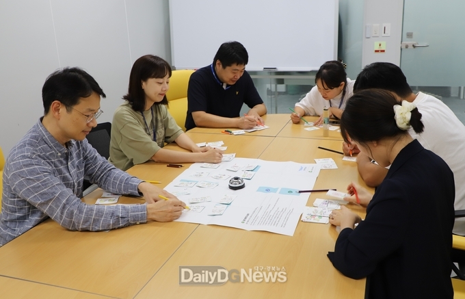 도레이첨단소재 제공)도레이첨단소재 직원들이 시각장애 아동이 그린 체인지카드를 채색하고 있다.