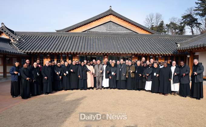 김재욱 칠곡군수(가운데)가 성 베네딕도회 오틸리엔 연합회 수도자들과 함께 향사아트센터에서‘럭키 칠곡’포즈로 기념 촬영을 하고 있다.