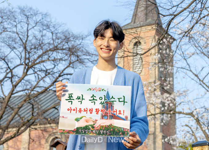 칠곡군 제공) 칠곡군 가실성당 앞에서 순심고 1학년 김민준 학생이 푯말을 들고‘가실성당 웨딩 챌린지’홍보에 참여하고 있다.