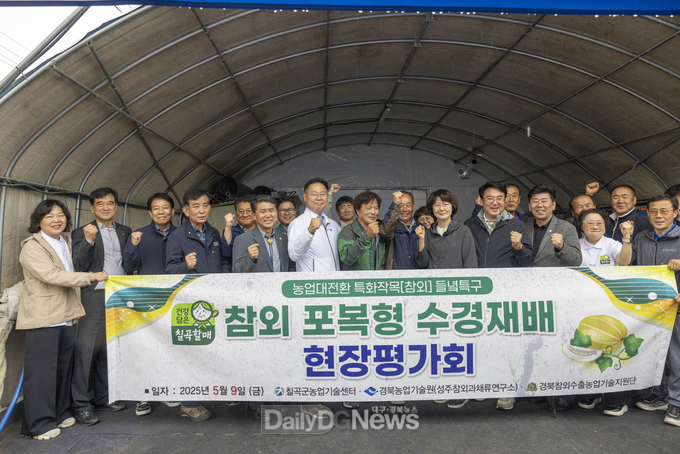 칠곡군 제공) 칠곡군 약목면 동안리에서 열린‘참외 포복형 수경재배 시범단지 현장평가회’에서 김재욱 칠곡군수(가운데)와 관계자, 농업인들이 기념촬영을 하고 있다.
