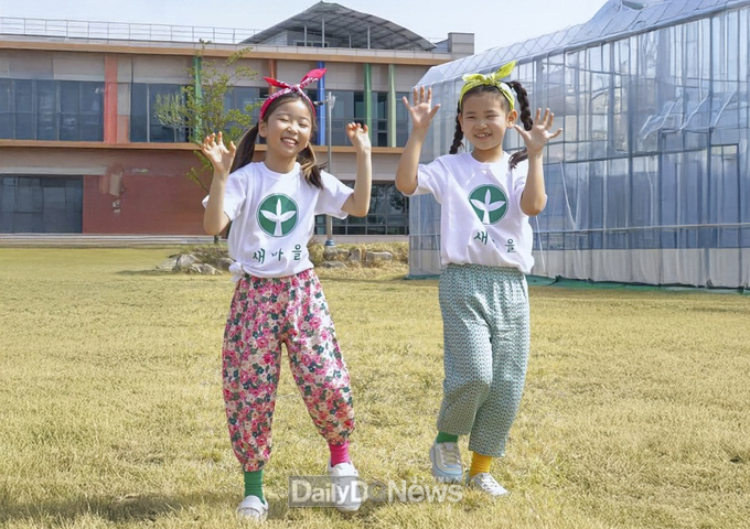 칠곡군 제공) 몸빼바지에 새마을 티셔츠를 입고‘건강담은 칠곡할매 챌린지’ 안무를 선보이는 김우리(오른쪽), 김민서(왼쪽) 양.