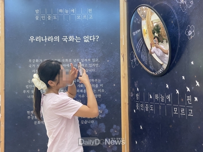 국립백두대간수목원을 찾은 관람객이 방문자센터에 조성된 무궁화 전시물 앞에서 사진을 찍고 있다.