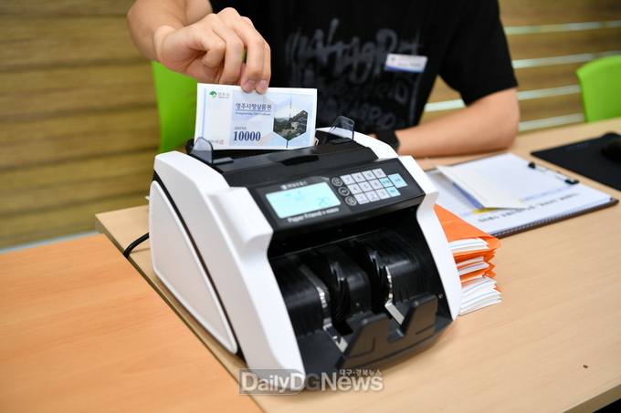 소비쿠폰 지급을 위해 지류상품권을 세고 있다