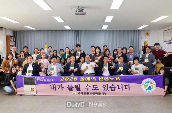 김재욱 칠곡군수를 비롯한 주요 내빈과 새마을문고 칠곡군지부 회원들이 ‘2025 올해의 선정도서를 선포한 뒤 함께 책을 들어 보이고 있다